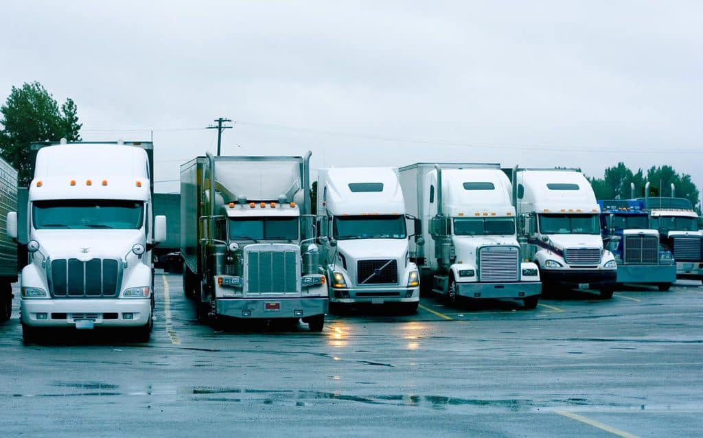 A large group of semi trucks at a truckstop