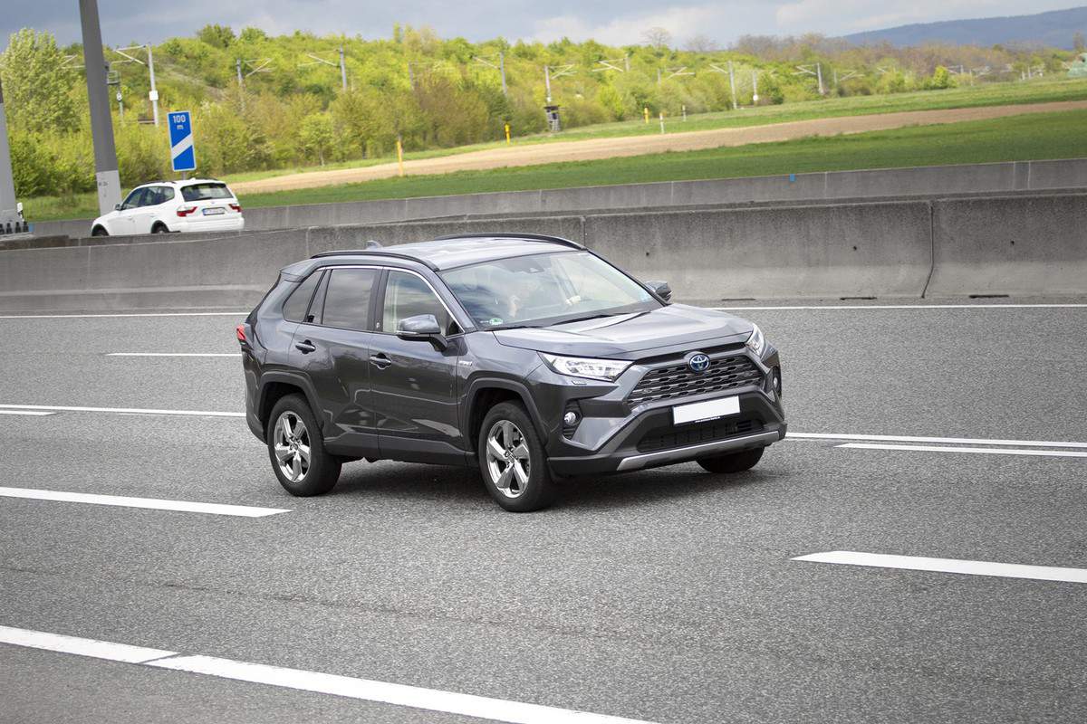 A middle-aged man in Toyota RAV4 Hybrid driving on a highway
