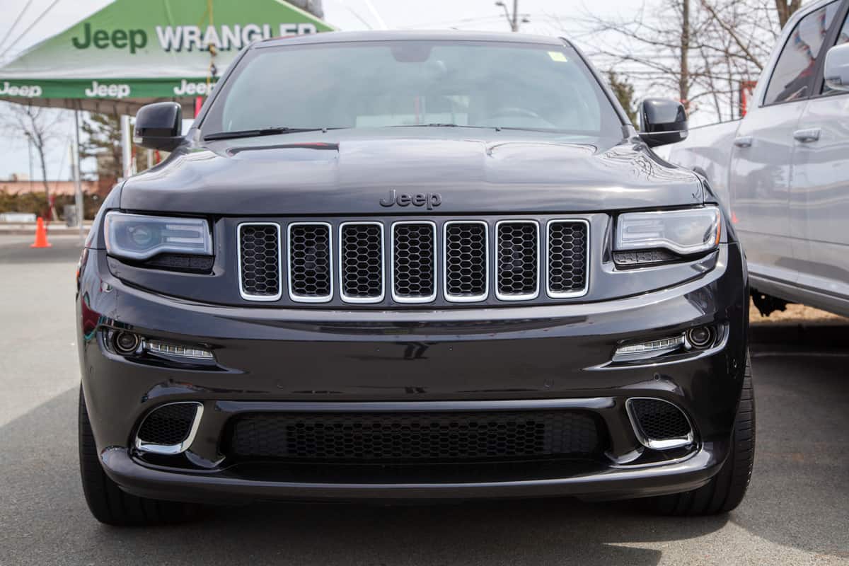 A new 2014 Jeep Grand Cherokee SRT on display on a car dealership lot.
