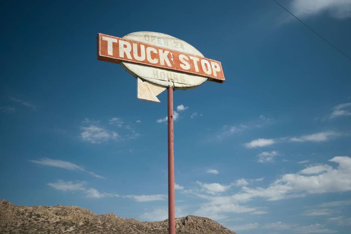 A truck stop sign on the side of the road