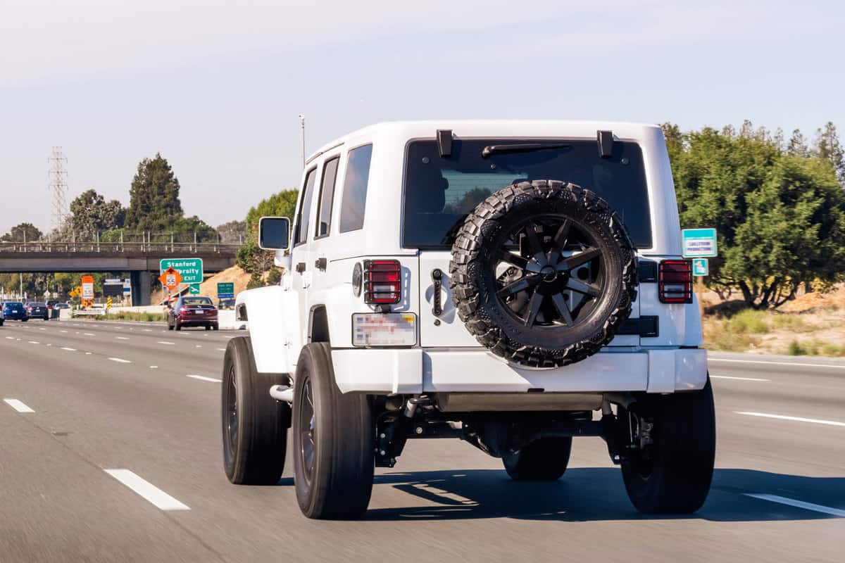 A white Jeep Wrangler moving on the expressway