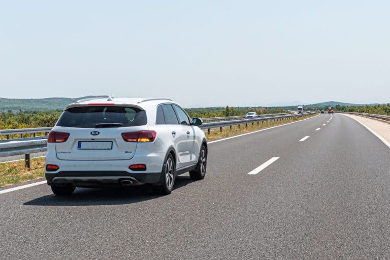 A white Kia Sorento moving along the highway, Does The Kia Sorento Have All Wheel Drive?