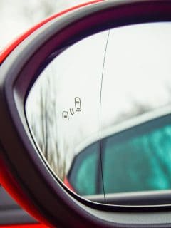 A blind spot monitoring system warning light in side view mirror of a modern vehicle, How To Turn On Blind Spot Monitor (BSM) In A Toyota RAV4?