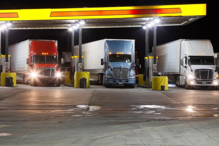 A group of semi trucks at truck stop gas pump in the night, How Much Do Showers At Truck Stops Cost?