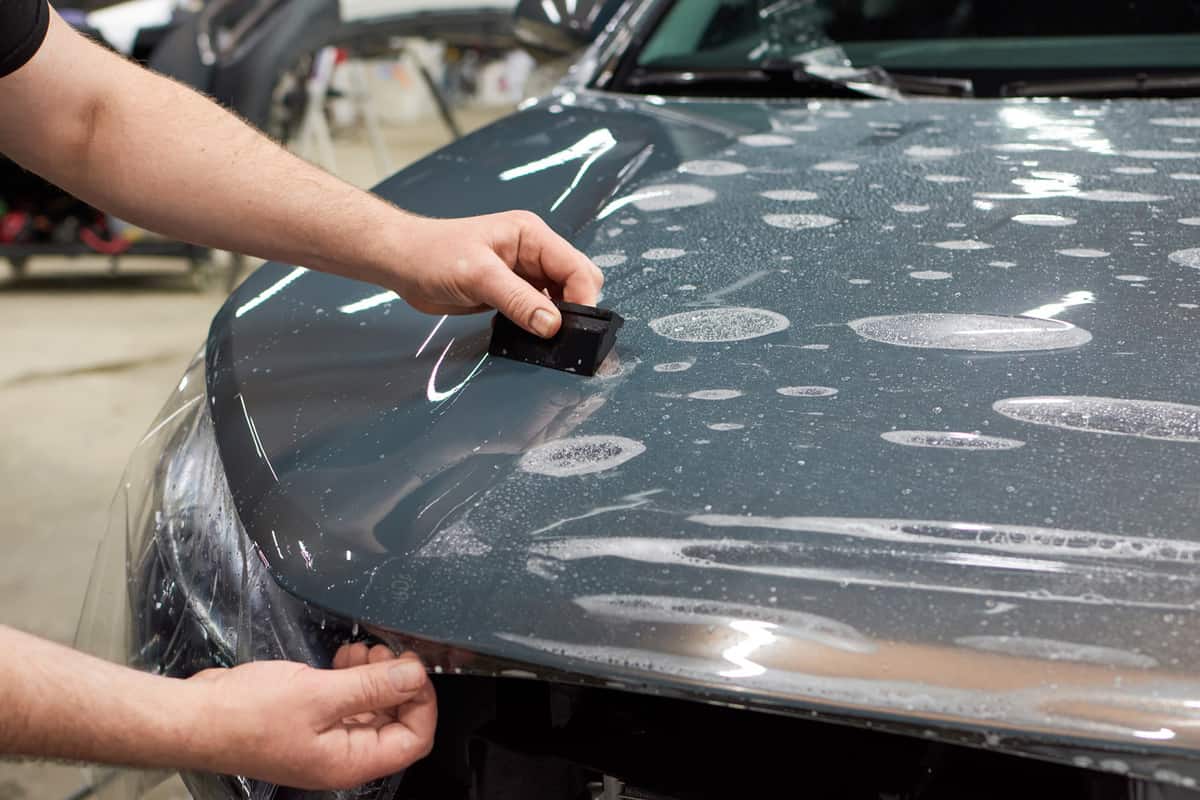 Installation of a protective paint and varnish transparent film on the car.