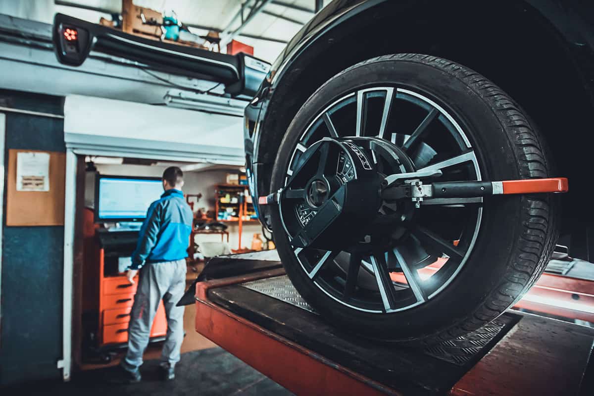 Mechanic removing the wheel of a car to install a spacer or for wheel alignment