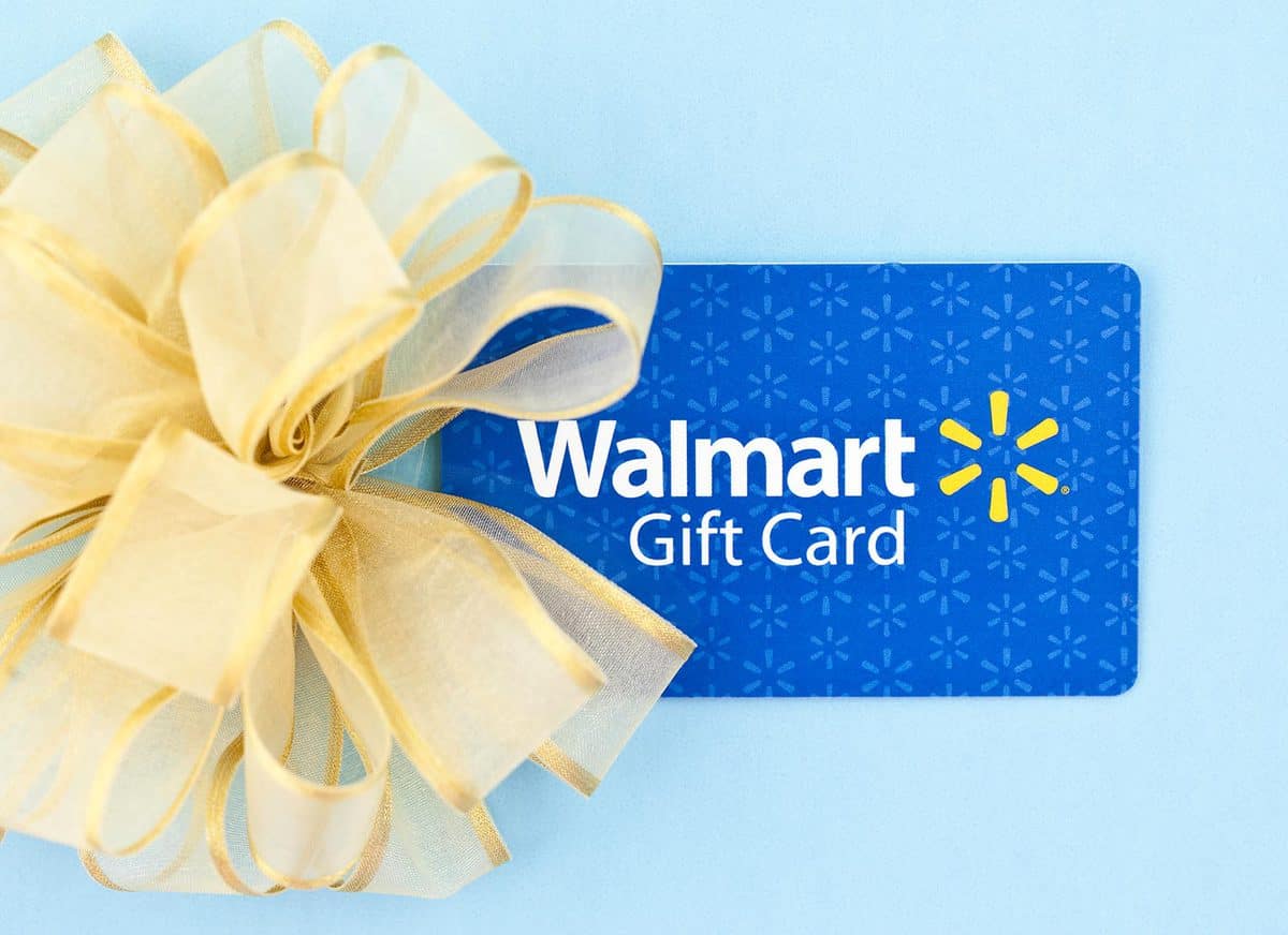 Horizontal studio shot of a WalMart gift card and a gold bow photographed