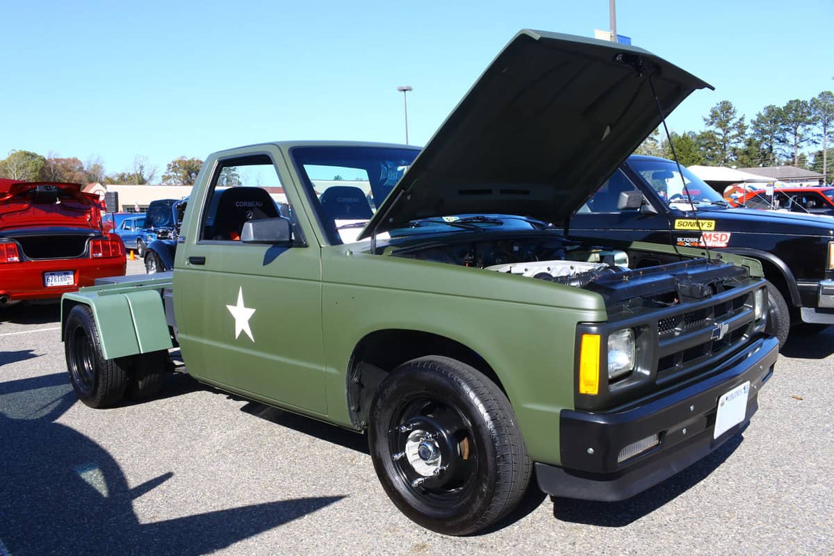 A green dually tire truck with an opened truck hood