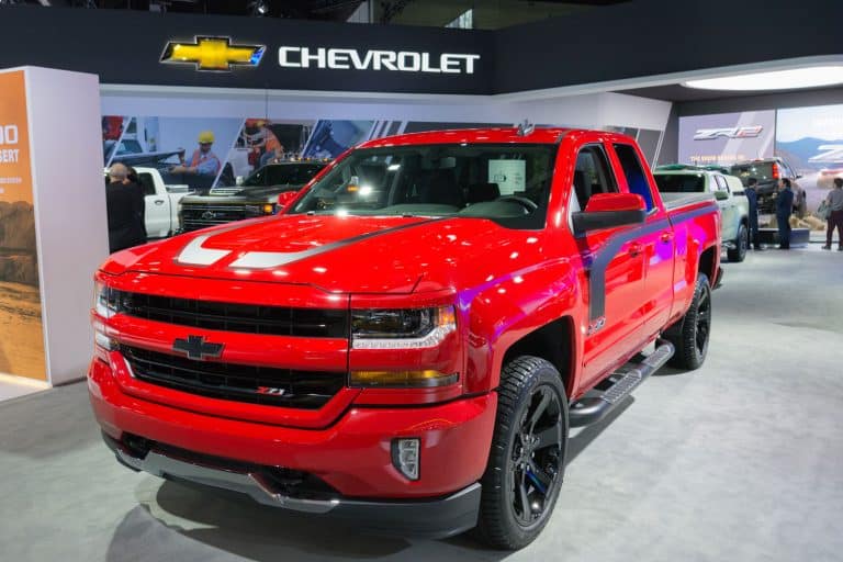 A red Chevrolet Silverado displayed at a car show, How Many Lugs On A Chevy Silverado? [Bolt Patterns Explained]