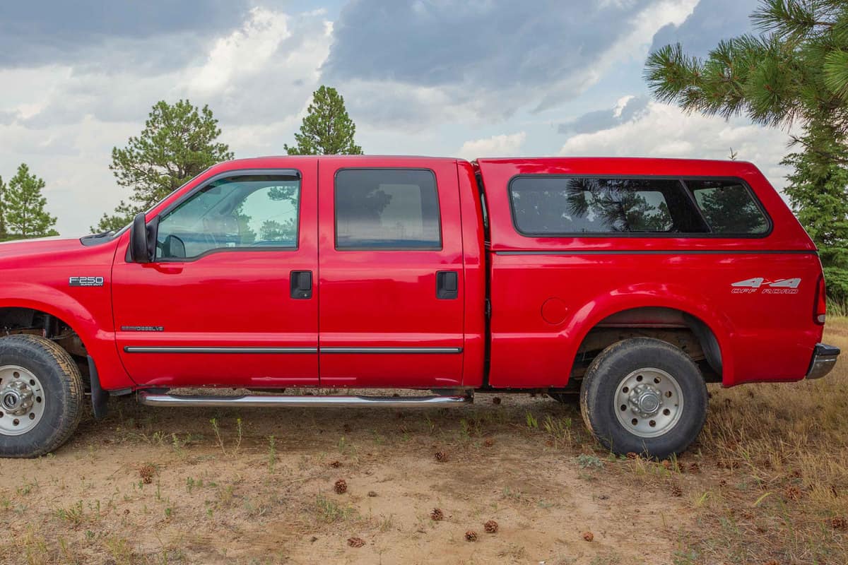 A red Ford F250 4X4 with a truck cap