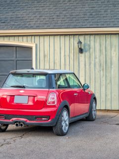 A red colored Mini Cooper parked near the garage, Not Using Your Car For a Long Time? Here Are 12 Things To Do