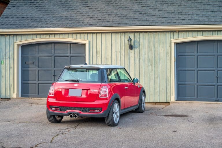A red colored Mini Cooper parked near the garage, Not Using Your Car For a Long Time? Here Are 12 Things To Do