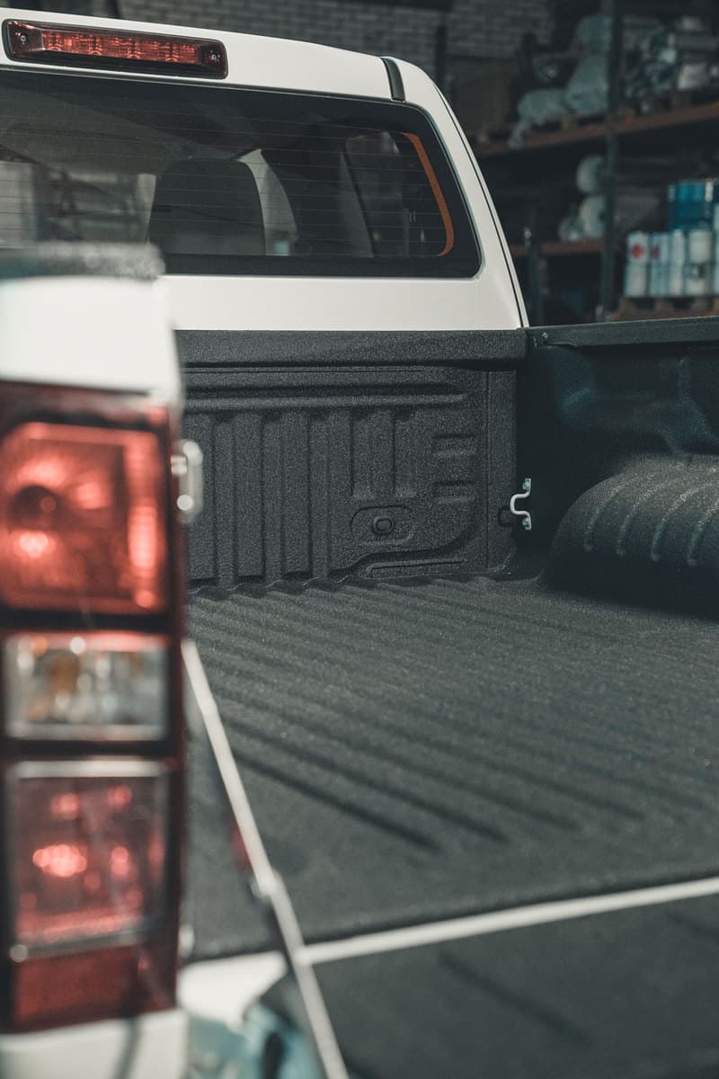 An opened back door of a truck showing the bed liner