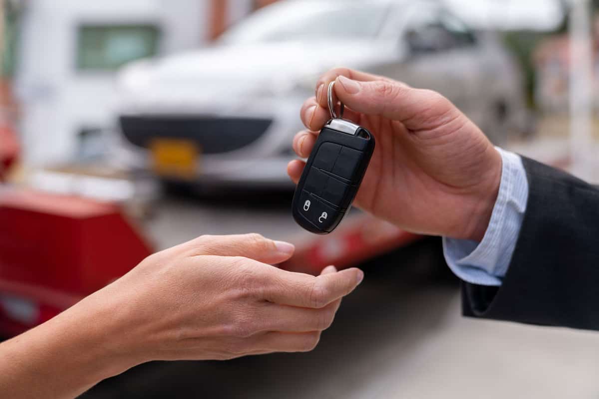 Car dealer giving the car keys to the new car owner