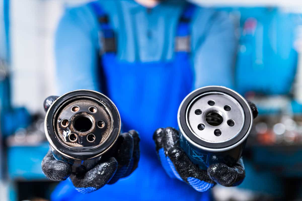Car mechanic comparing old and new oil filters