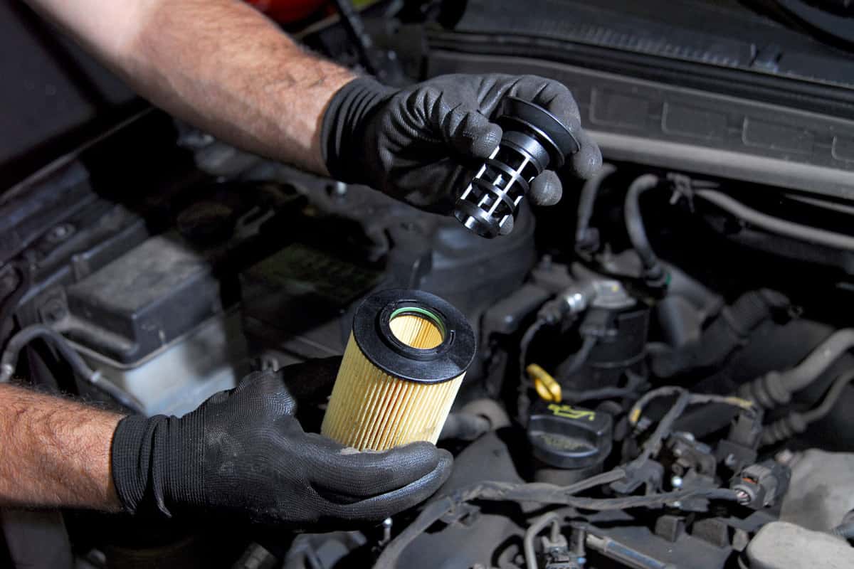 Car technician checking the strainer of the oil filter