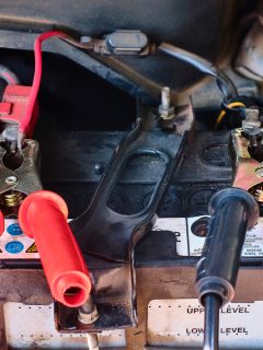 Close up of jumper cable clip on battery terminals for jump start a car or pick up truck. Jump start an old car battery in the engine bay. - Can You Jump Start A Truck With A Car?
