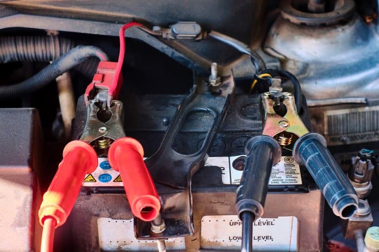 Close up of jumper cable clip on battery terminals for jump start a car or pick up truck. Jump start an old car battery in the engine bay. - Can You Jump Start A Truck With A Car?