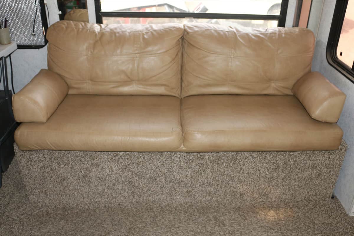 Cream colored RV couch that opens to double bed