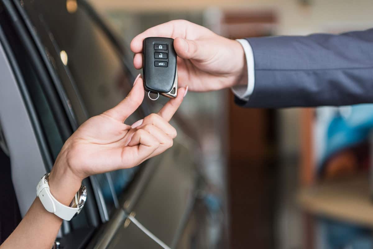Dealership owner giving the car keys to the new car owner