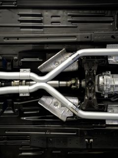 Exhaust manifold photographed under a car, How Much Does It Cost To Straight Pipe A Car Or Truck?