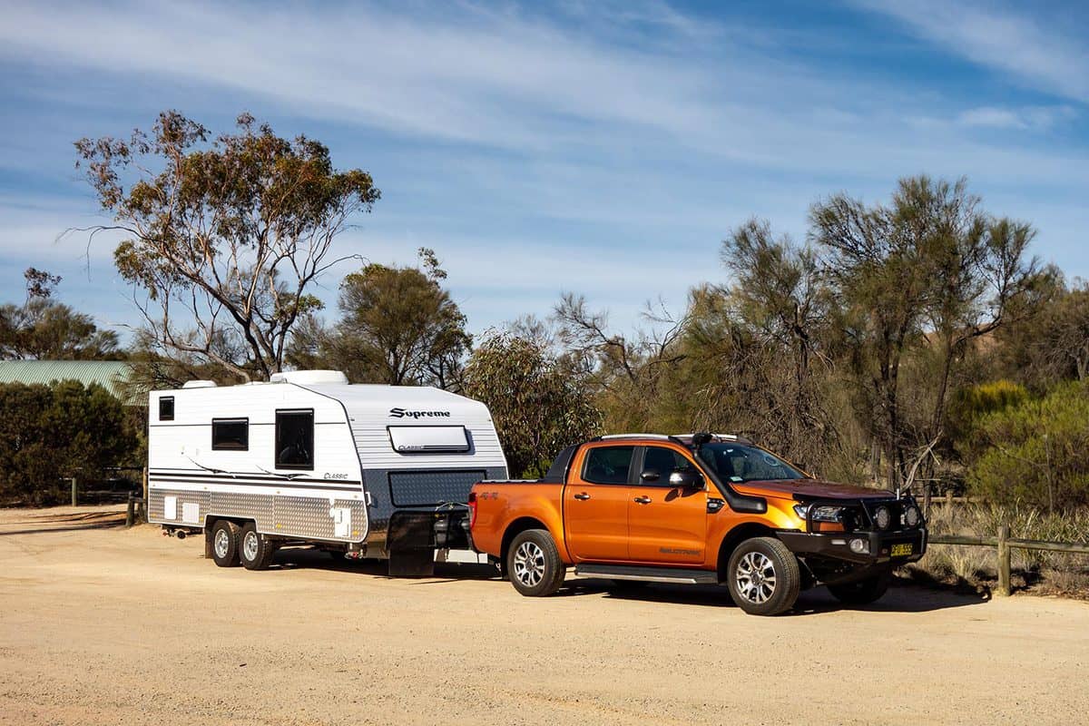 Ford Ranger Wildtrack off road pickup car with air intakes and a white caravan trailer in Western Australia prepared for an adventure