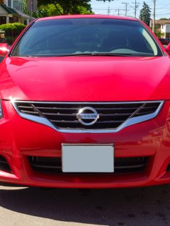 Front view of a fourth generation, red colored, Nissan - How Many Miles To The Gallon Does A Nissan Altima Do