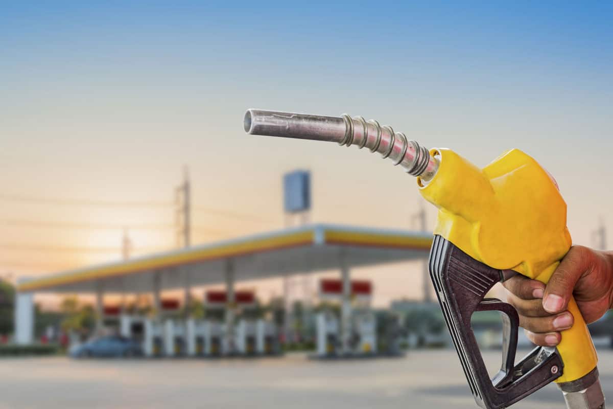 Holding a fuel nozzle against with gas station