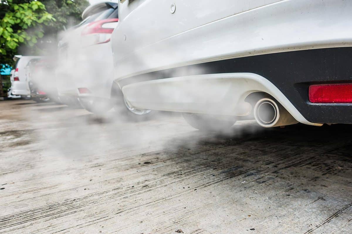 Incomplete combustion creates poisonous carbon monoxide from exhaust pipe of white car