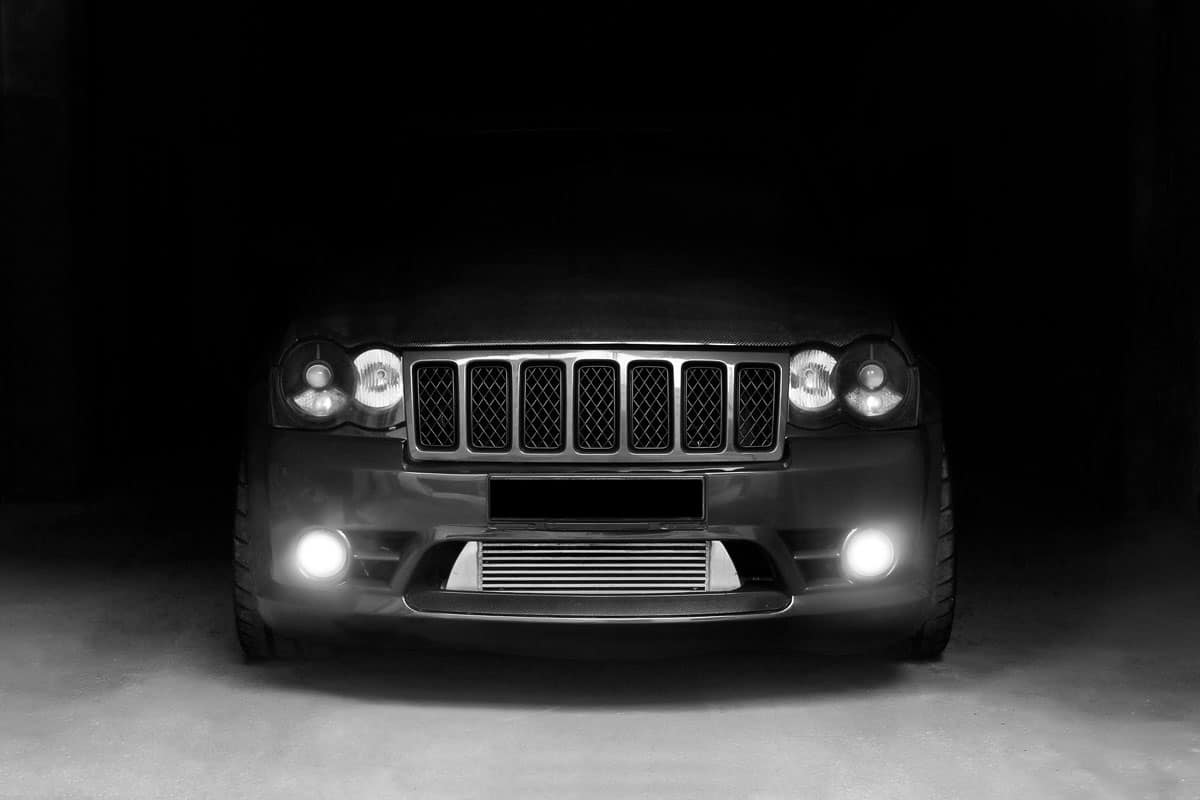 Jeep Grand Cherokee SRT8 in the shadows with glowing lights in low light