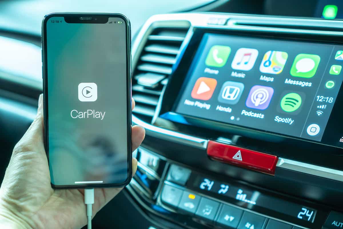 Man holding his phone switching to Apple car play
