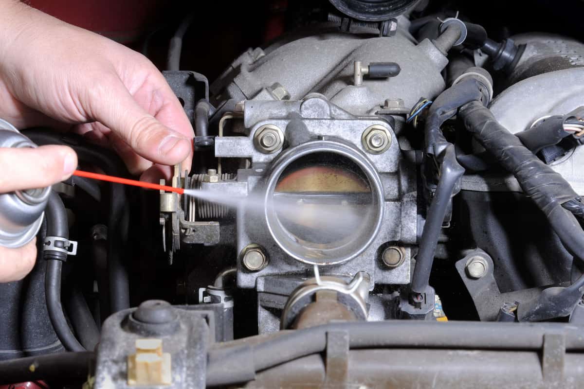 Mechanic checking and cleaning the throttle body of an engine