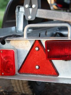 trailer detachable rear bumper panel with tail lights and triangle reflector closeup with disconnected plug cable - Trailer Running Lights Not Working - What To Do