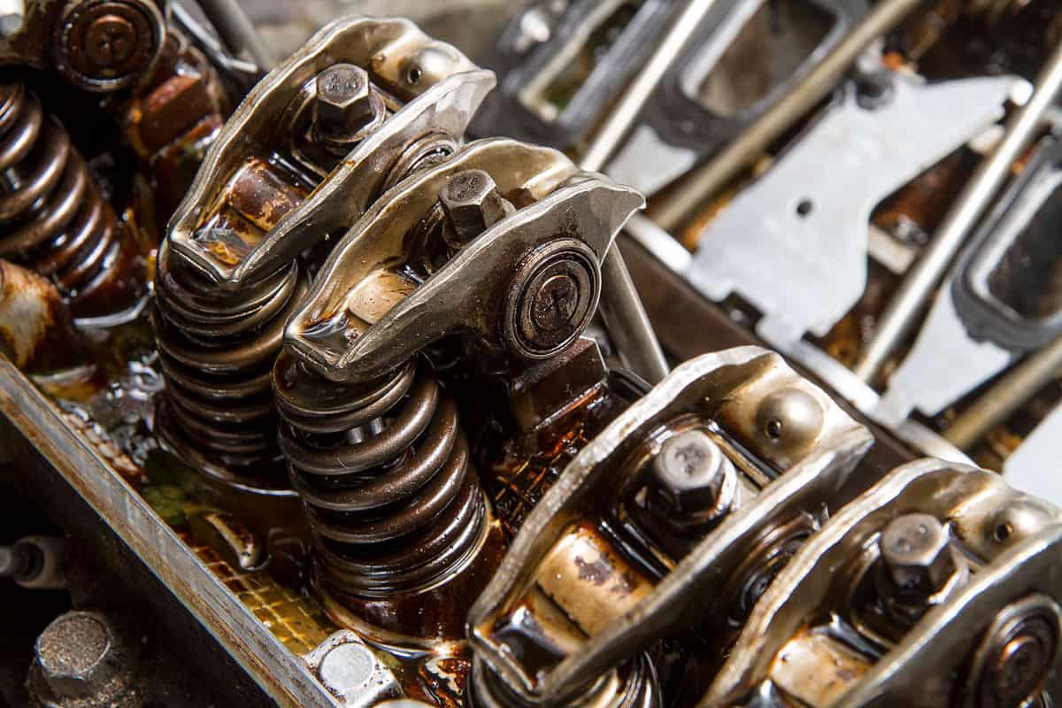 Oily rocker arms and springs inside a disassembled engine assembly