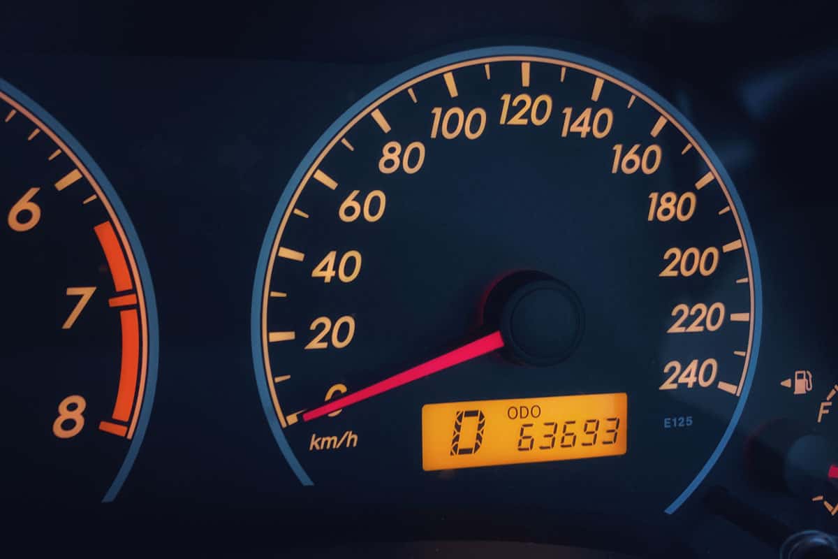 Orange colored light dashboard of stop car with 63693 kilometers odometer