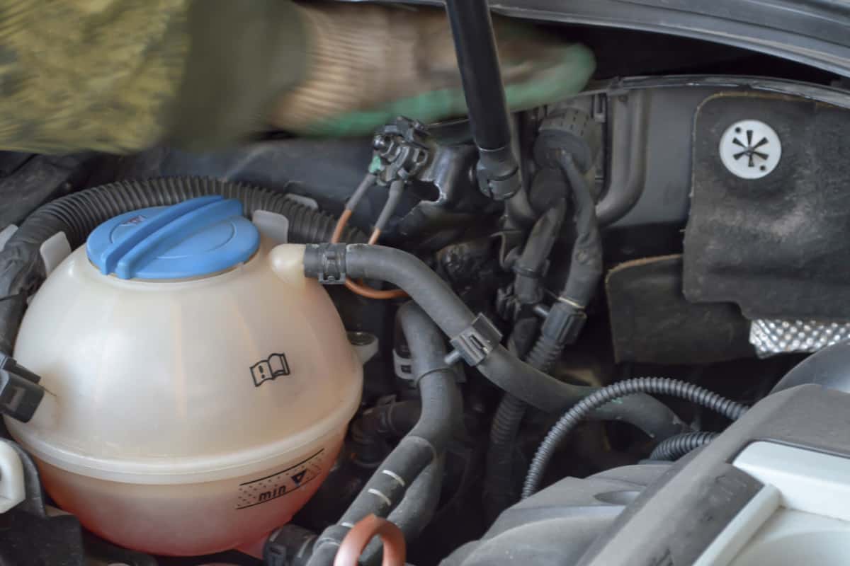 Plastic expansion tank of the car internal combustion engine cooling system installed under the hood