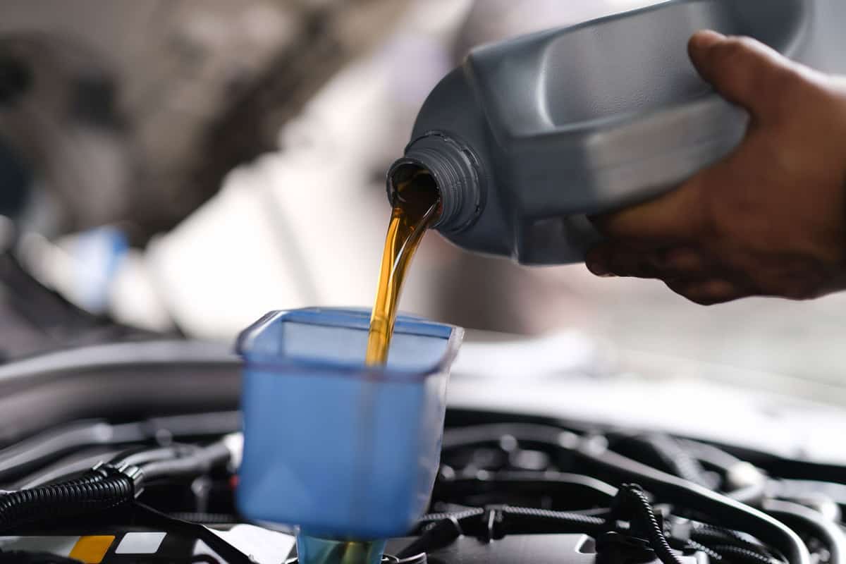 Pouring new engine oil to the car engine