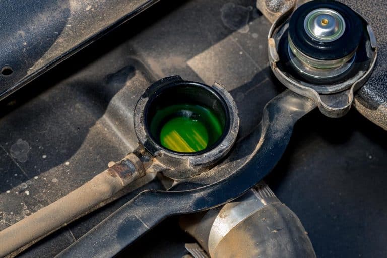 A radiator with cap removed showing green antifreeze coolant level inside, Where Does Antifreeze/Coolant Go In Your Car?