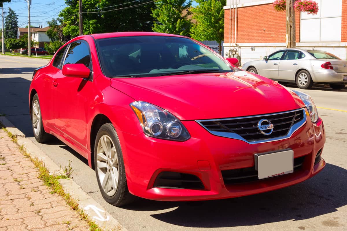 Red colored fourth generation Nissan Altima coupe parked on the street