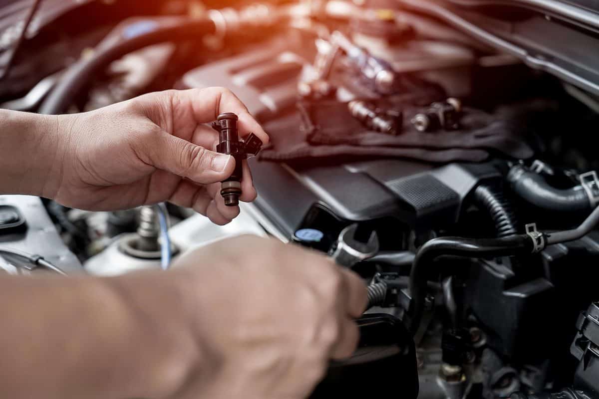 Technician use wrench removing the gasoline injector part on engine maintenance
