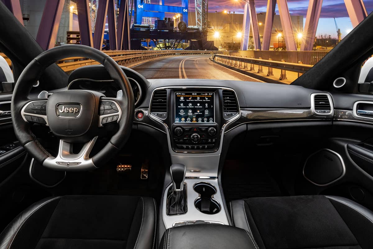 cockpit and steering wheel of the Jeep Grand Cherokee Trackhawk driving at night on a steel bridge