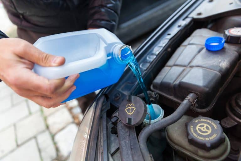 man pours anti-freeze fluid into his car - What Color Coolant Does Toyota Use