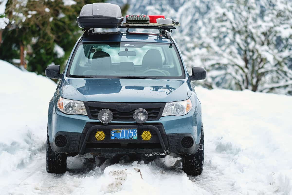 A Subaru Forester modified for offroad use on a snowy country lane