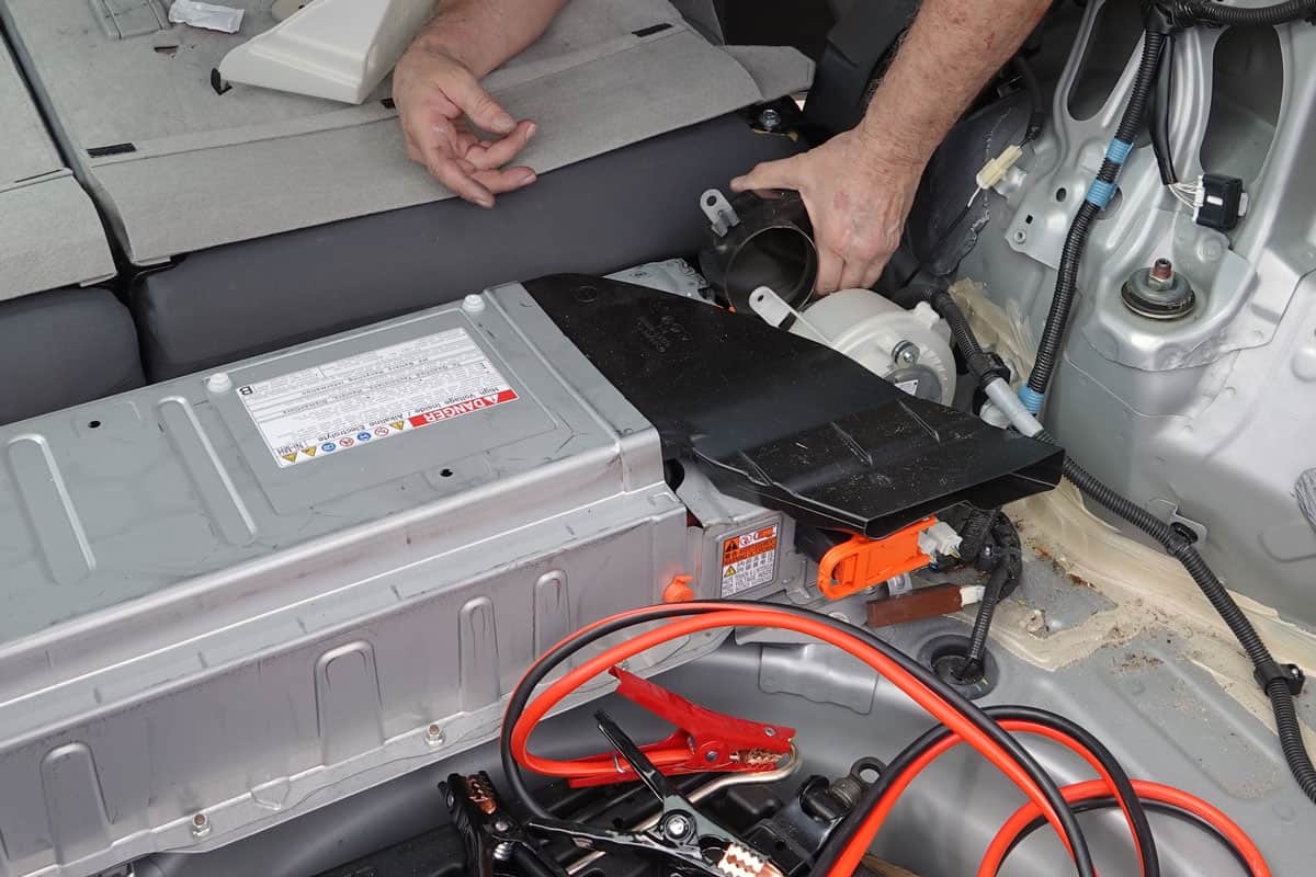A man accessing the hybrid battery fan in 2011 Toyota Prius