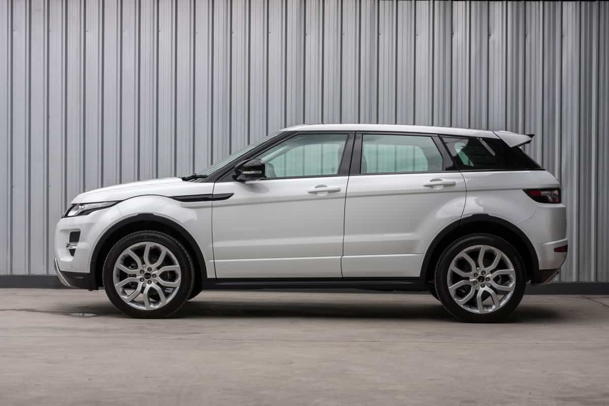 A photo of a parked White 2012 range rover evoque 2012 on display outside of a car dealership