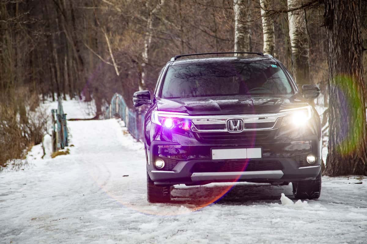 Black Honda Pilot trekking on a snowy road