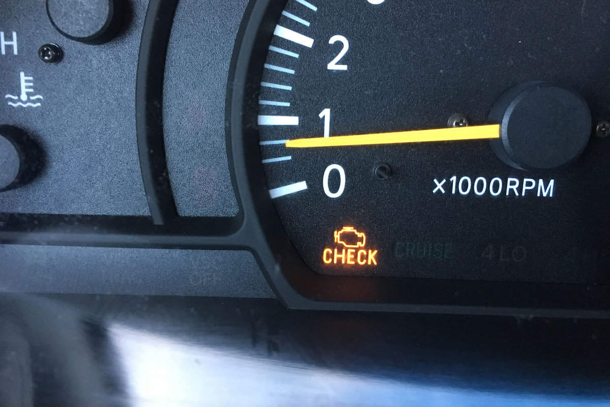 Check engine indicator glowing at the car dashboard
