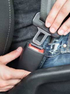 Closeup of man fastening seat belt in car, How To Turn Off Seatbelt Alarm In A Subaru