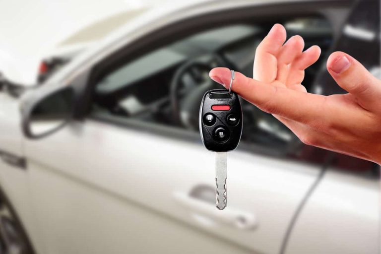 Dealer hand with a car key - What's A Good Price For A First Car [Inc. 7 Examples]