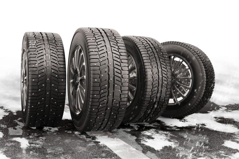 Four car tires rolling on a snow-covered road - How To Remove Studs From Tires